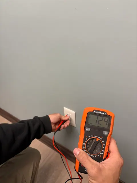 Checking voltage at a wall outlet.