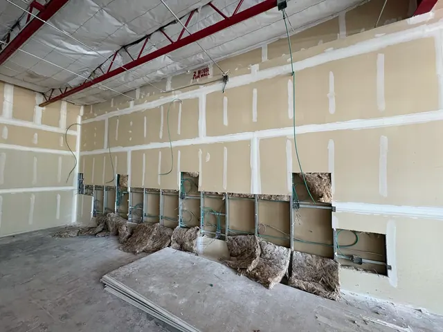 Commercial wall circuit installation before drywall repairs.