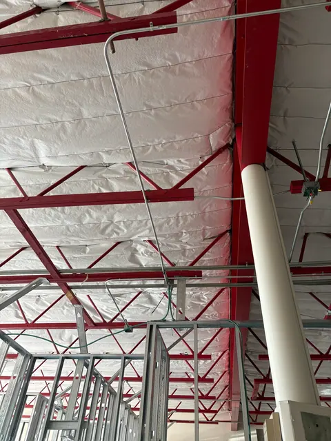 Conduit and circuit drops above new commercial partitions.