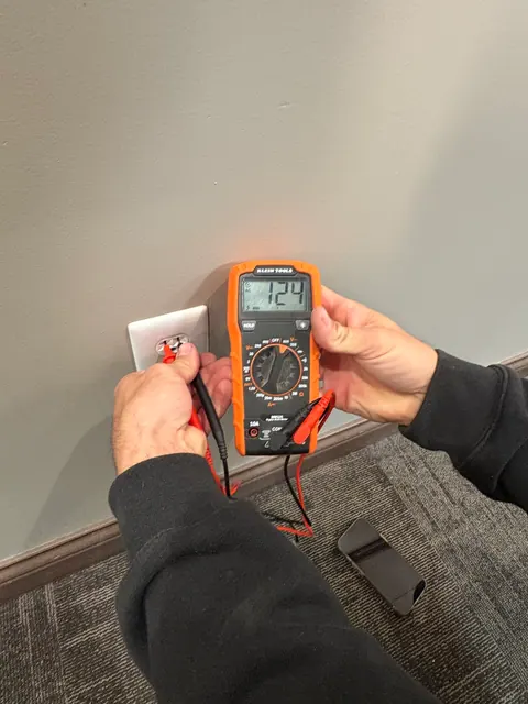 Measuring voltage at a duplex receptacle.