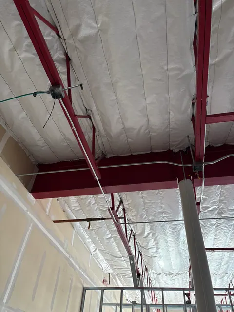 Overhead conduit routing through a commercial interior.