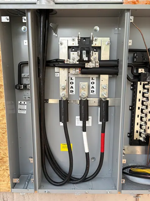 Service conductors inside a meter-main panel during installation.