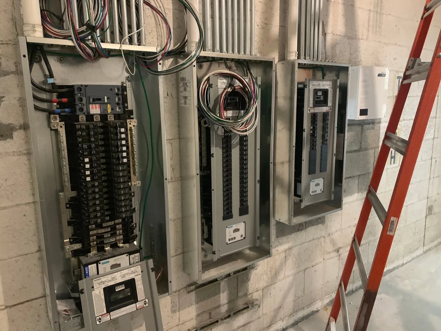 Gray Electric technician working inside an open electrical panel
